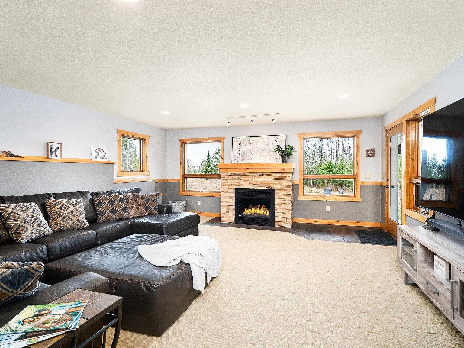 The lower level rec room with a fireplace and sectional